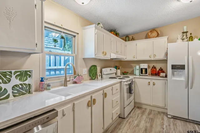 a kitchen with stainless steel appliances granite countertop a refrigerator sink and cabinets