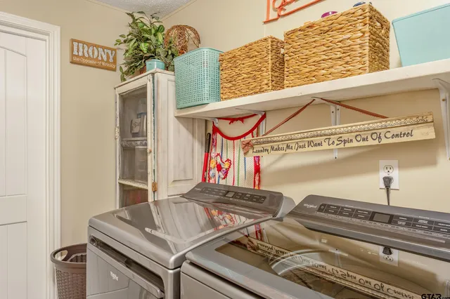 a view of a house with potted plants and a large tree