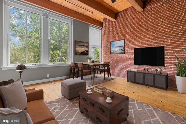 a living room with furniture a flat screen tv and a floor to ceiling window