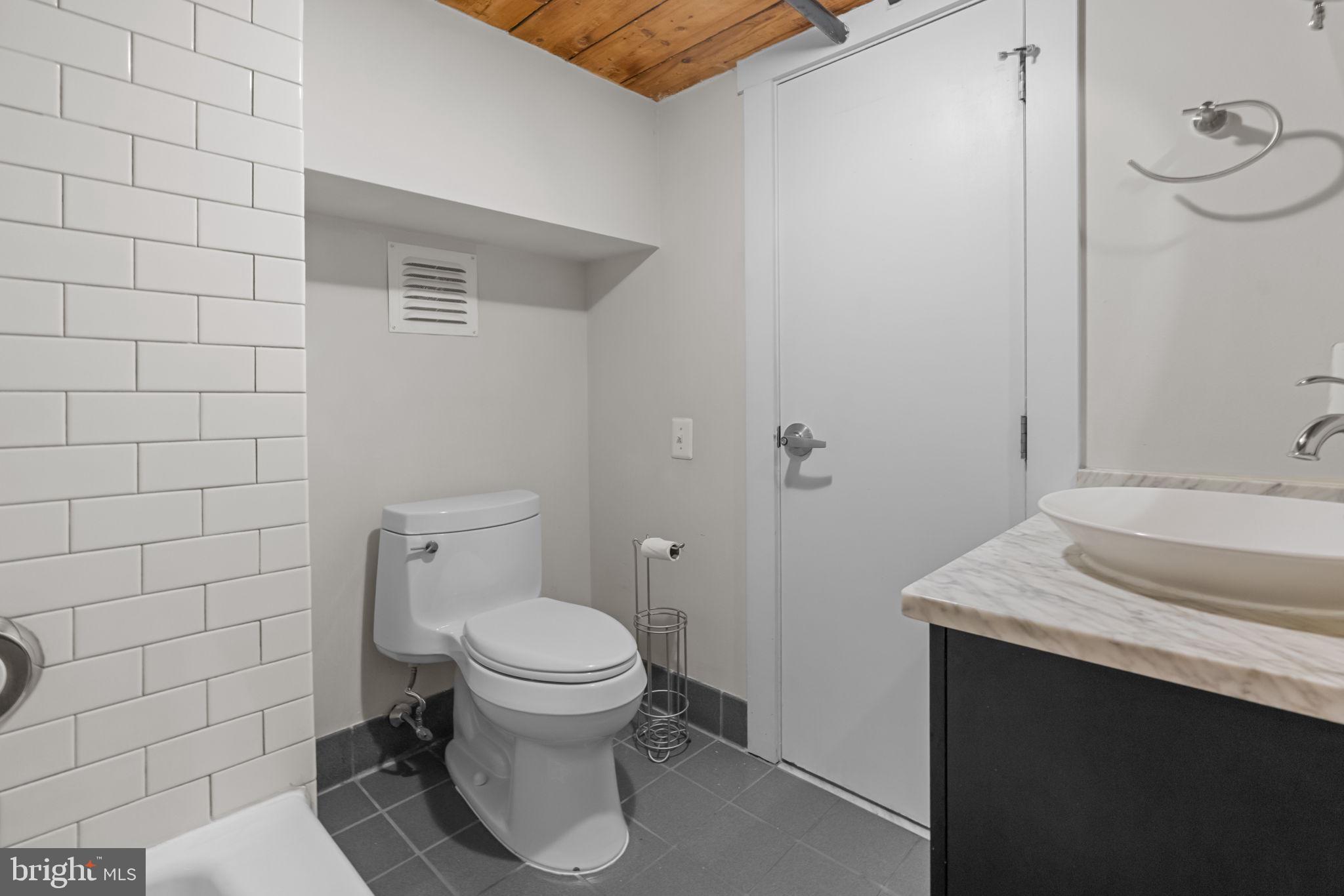 309 Arch Street, Unit 301 Philadelphia, PA 19106 - Photo 12 of 36 a bathroom with a granite countertop toilet sink and mirror