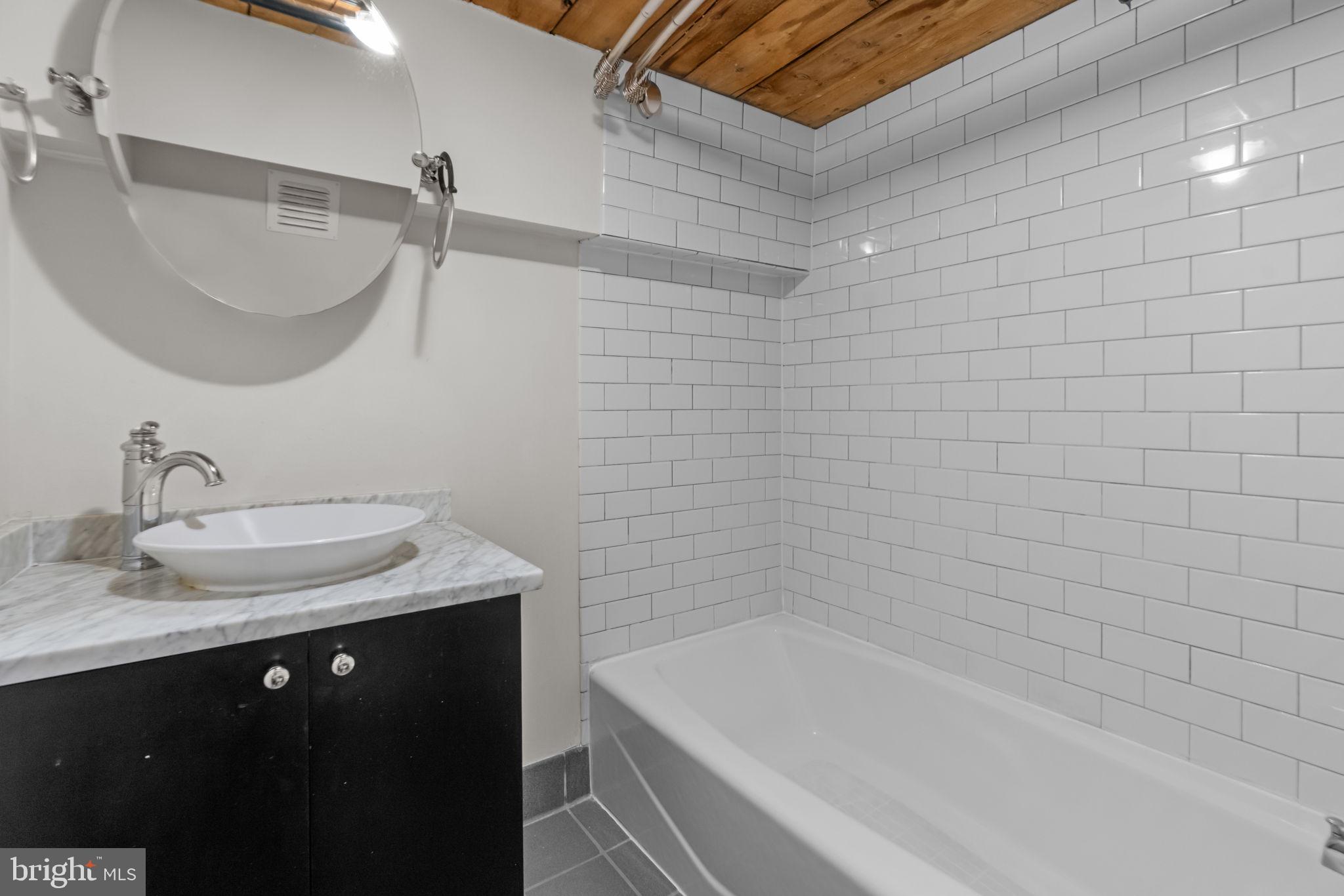 309 Arch Street, Unit 301 Philadelphia, PA 19106 - Photo 13 of 36 a bathroom with a granite countertop sink a toilet and bathtub