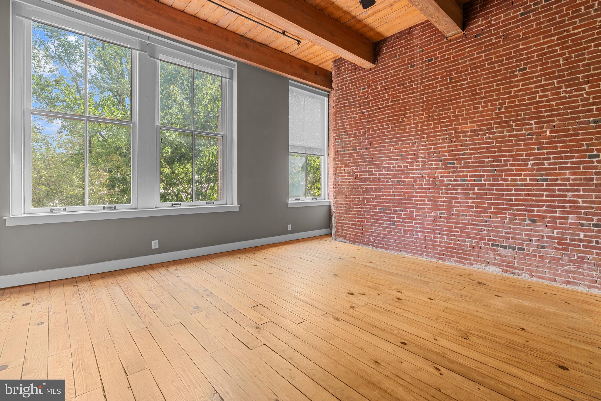 309 Arch Street, Unit 301 Philadelphia, PA 19106 - Photo 21 of 36 a view of an empty room with a window and wooden floor