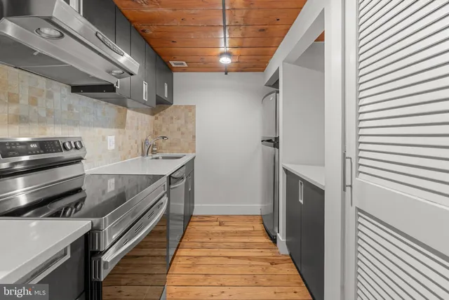 a view of an empty room with stairs and wooden floor