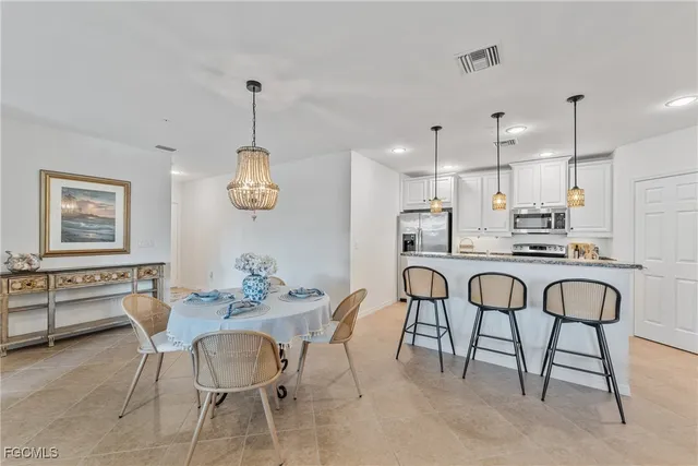 a dining room filled chandelier and kitchen view