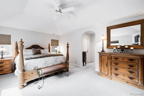 a bedroom with a large bed and a chandelier