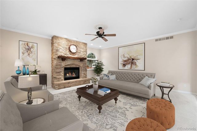 a living room with furniture a clock and a fireplace