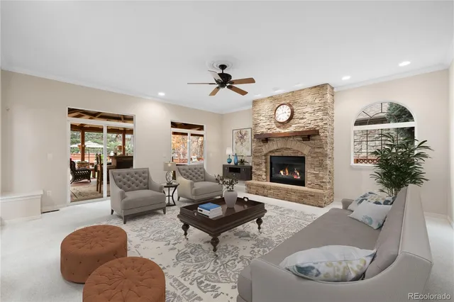 a living room with furniture a fireplace and a chandelier