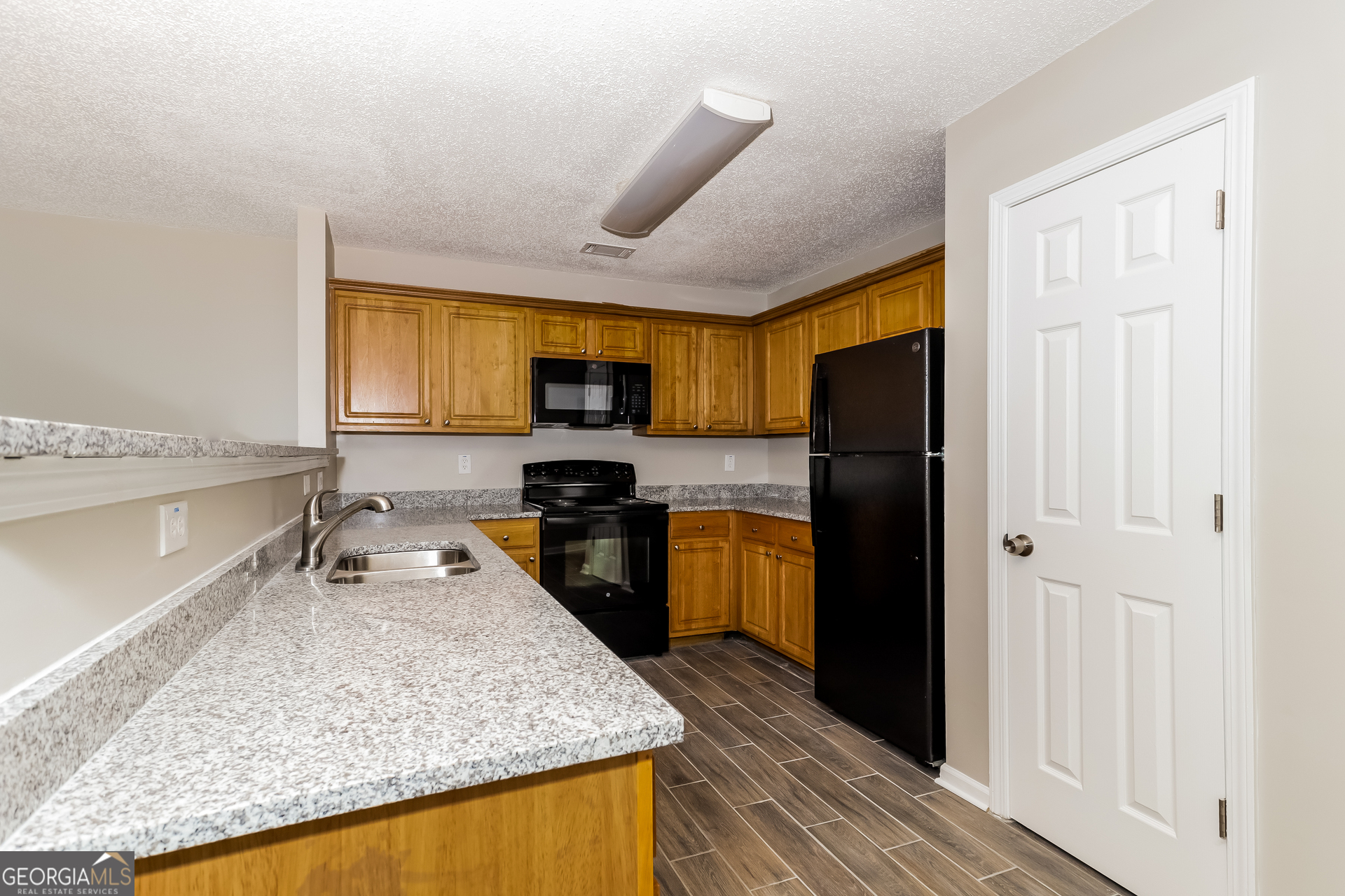 5319 Creekview Way Morrow, GA 30260 - Photo 5 of 17 a kitchen with stainless steel appliances granite countertop a sink refrigerator stove and microwave