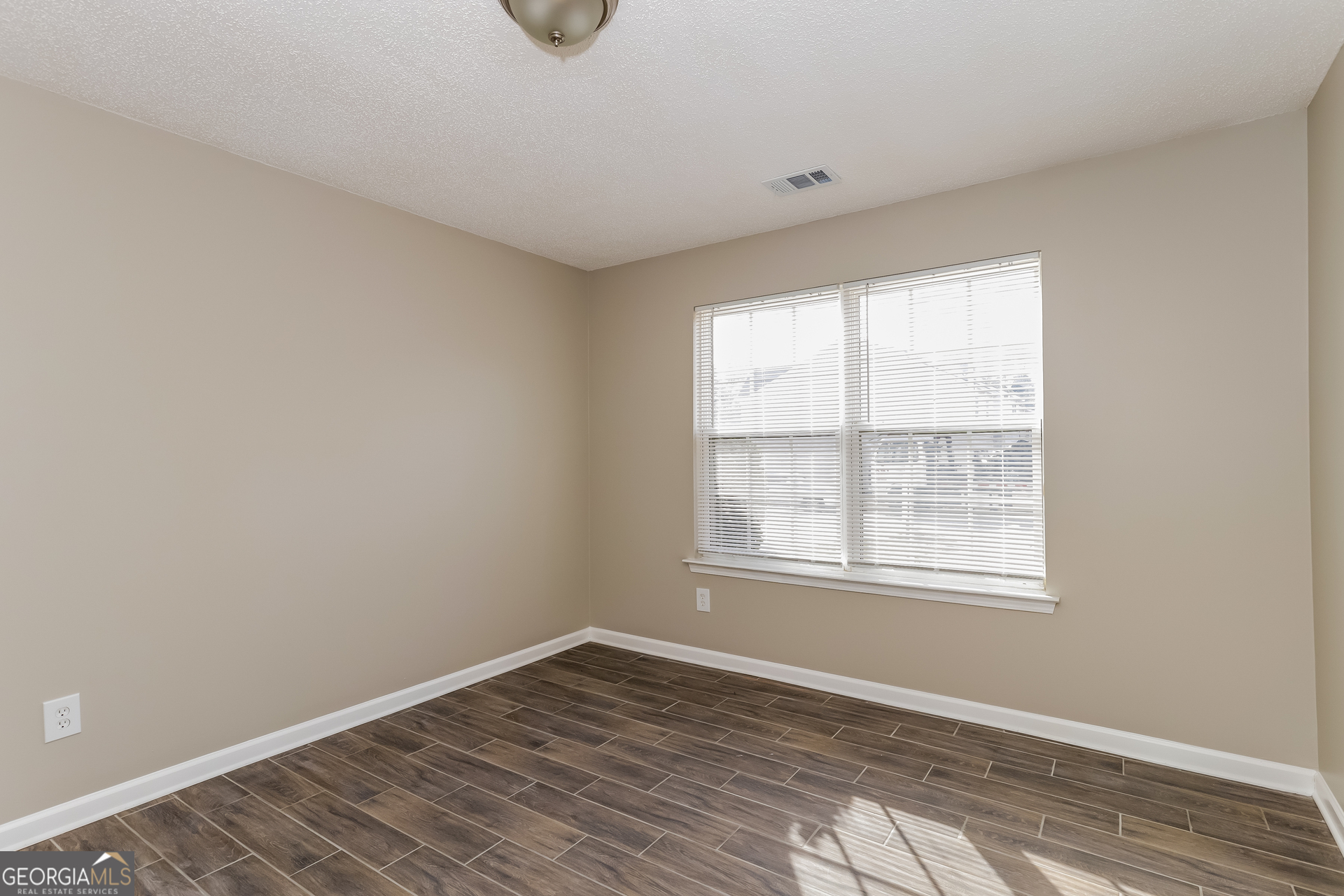 5319 Creekview Way Morrow, GA 30260 - Photo 9 of 17 an empty room with wooden floor and windows