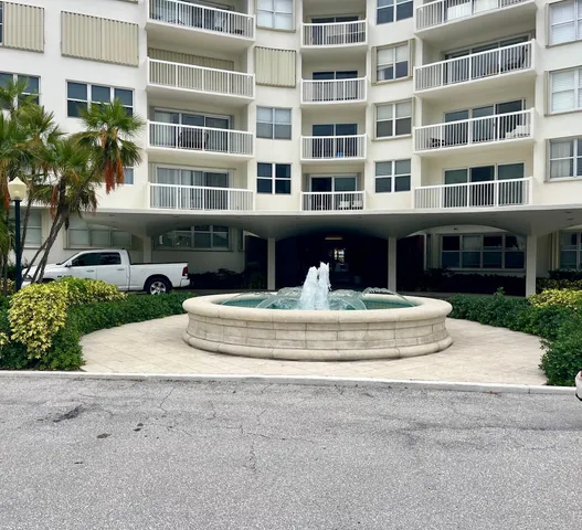 a front view of a building with a garden and plants
