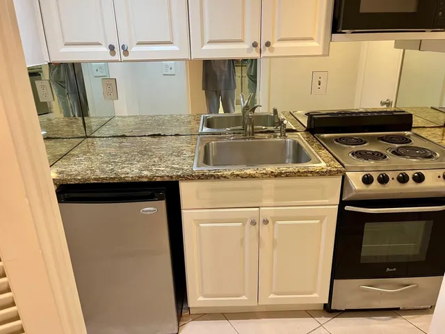 a kitchen with granite countertop a sink and a stove