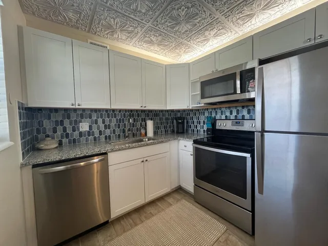 a kitchen with stainless steel appliances granite countertop a sink stove and refrigerator