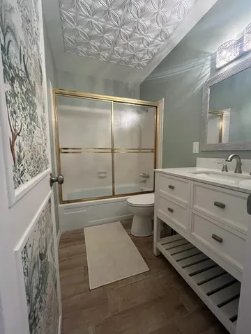 a bathroom with a sink a toilet and shower