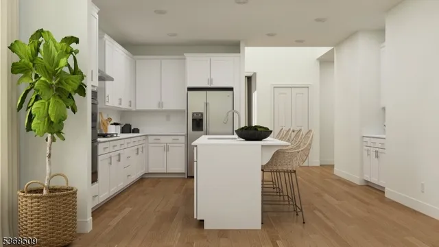 a kitchen with white cabinets and wooden floor