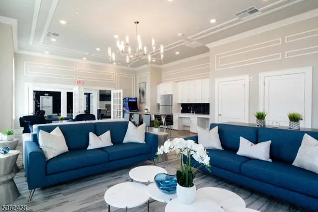a living room with furniture kitchen view and a chandelier