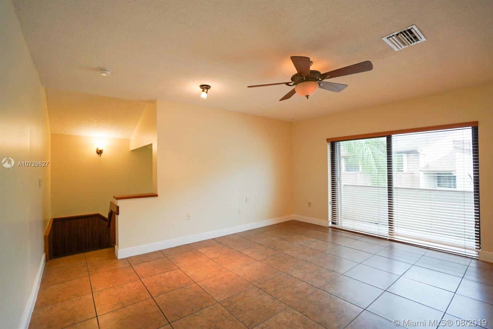 11501 Southwest 109th Road, Unit 13D Miami, FL 33176 - Photo 3 of 30 Tiled Flooring, Open Living Room with Ceiling Fan leading to Balcony Patio