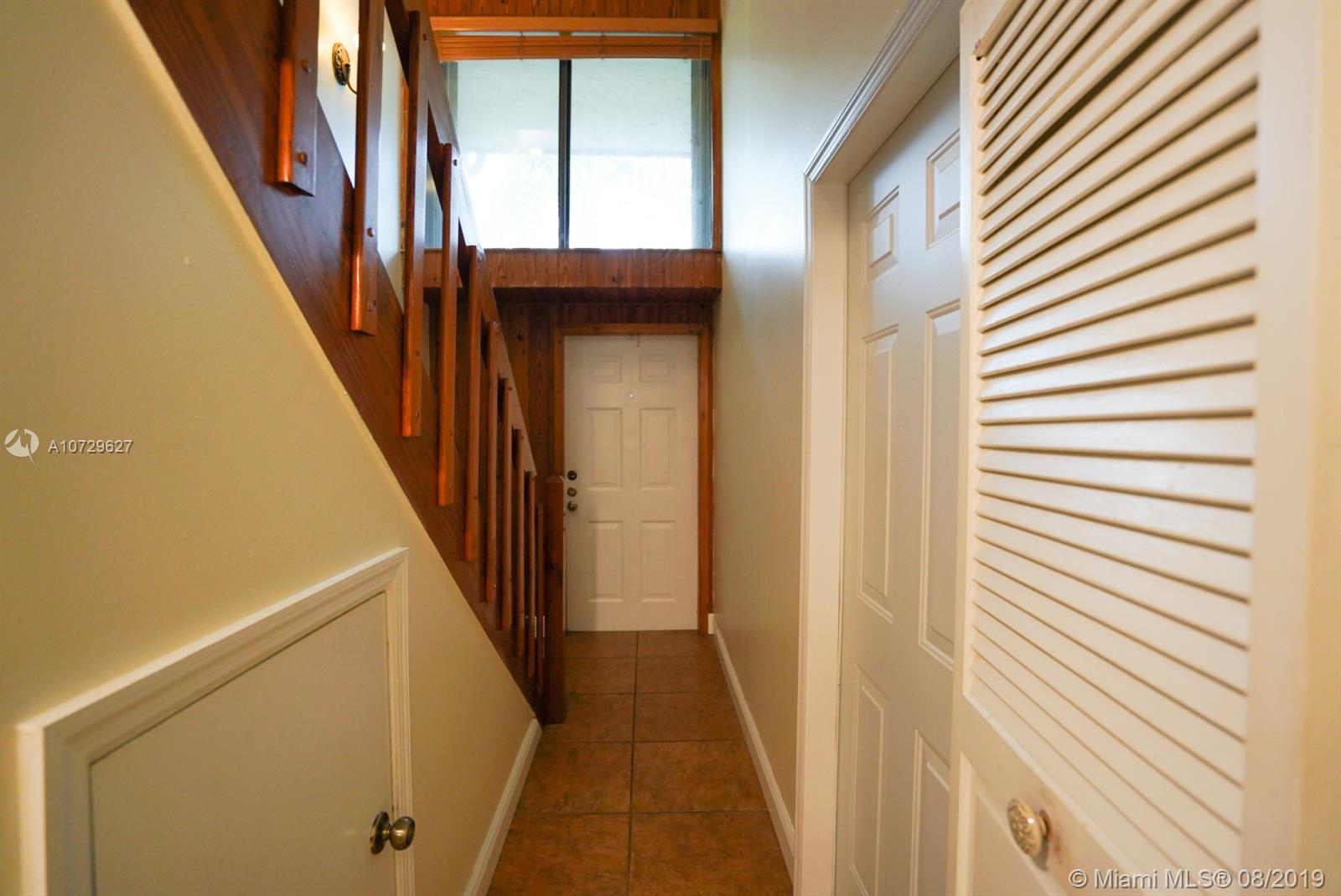 11501 Southwest 109th Road, Unit 13D Miami, FL 33176 - Photo 22 of 30 Foyer, Under Stairwell Storage, Entrance Door, 2nd story Exterior Window, Door to Garage