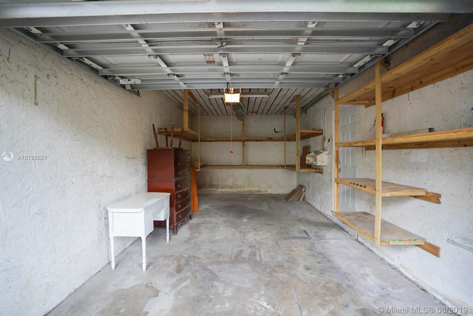 11501 Southwest 109th Road, Unit 13D Miami, FL 33176 - Photo 25 of 30 Garage Interior - Automatic Garage Door Opener; Shelving; Concrete Flooring