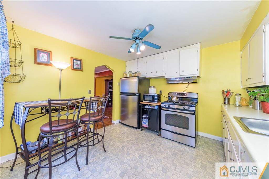 138 River Edge Road Bergenfield, NJ 07621 - Photo 12 of 28 a kitchen with stainless steel appliances kitchen island granite countertop a table and chairs in it