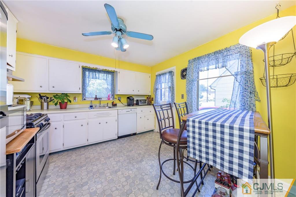 138 River Edge Road Bergenfield, NJ 07621 - Photo 13 of 28 a kitchen with a table chairs and a refrigerator