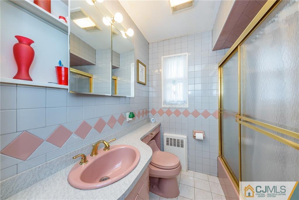 138 River Edge Road Bergenfield, NJ 07621 - Photo 16 of 28 a bathroom with a sink toilet mirror vanity and bathtub