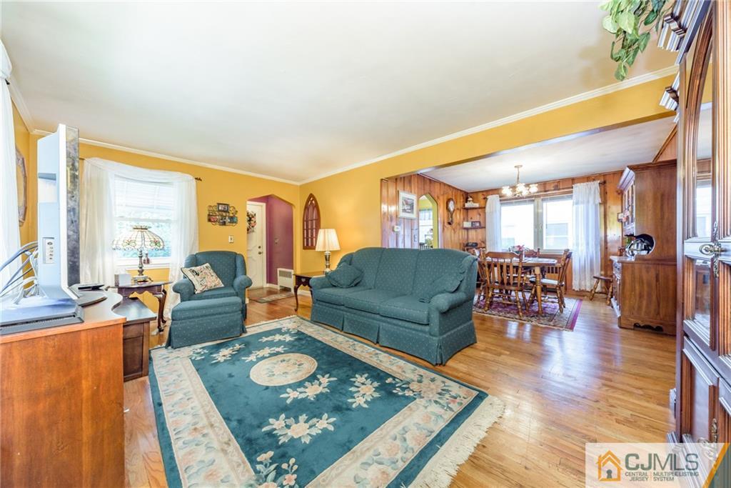 138 River Edge Road Bergenfield, NJ 07621 - Photo 3 of 28 a living room with furniture and a dining table with wooden floor