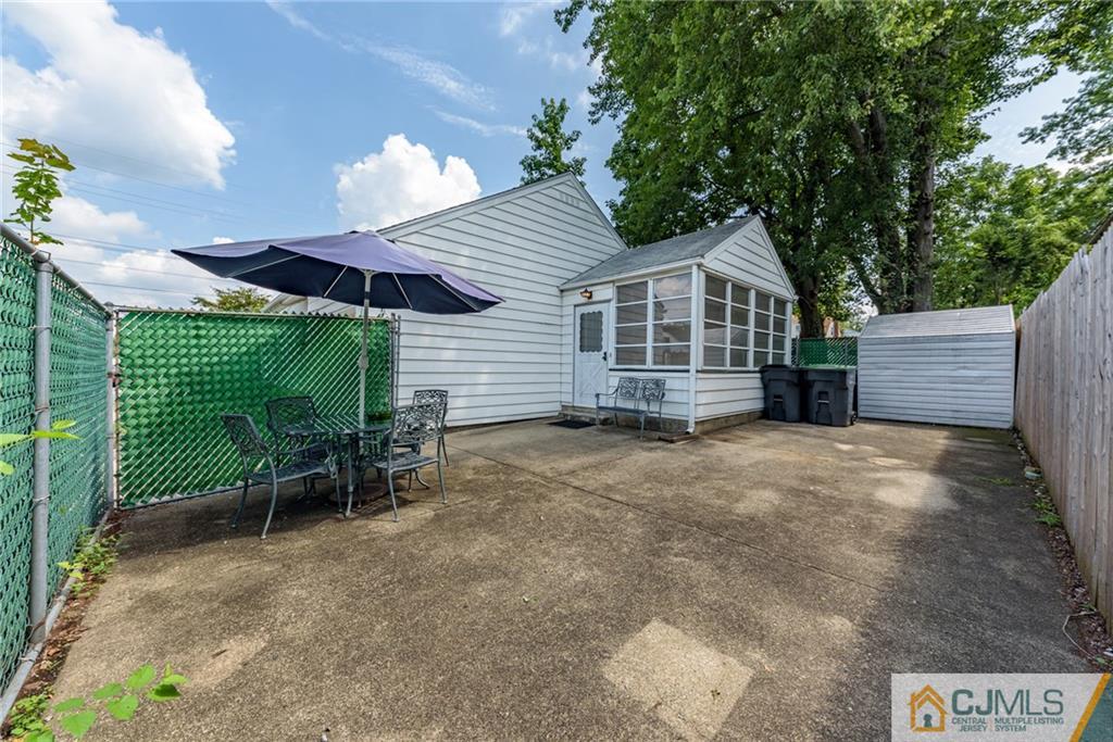 138 River Edge Road Bergenfield, NJ 07621 - Photo 25 of 28 a view of a house with a yard and lawn chairs under an umbrella