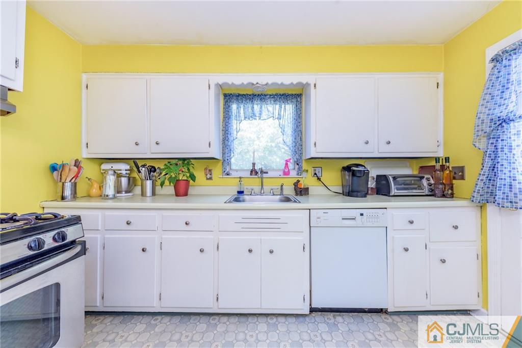 138 River Edge Road Bergenfield, NJ 07621 - Photo 9 of 28 a kitchen with white cabinets and a stove