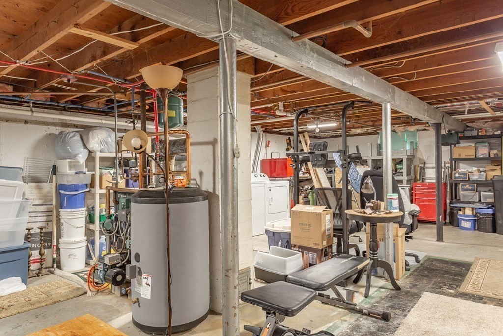 109 Oak Street Raynham, MA 02767 - Photo 18 of 25 a view of a storage room with water heater and racks