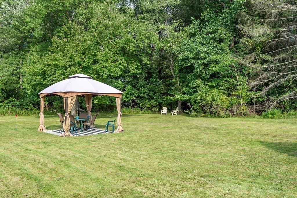 109 Oak Street Raynham, MA 02767 - Photo 21 of 25 a backyard of a house with table and chairs