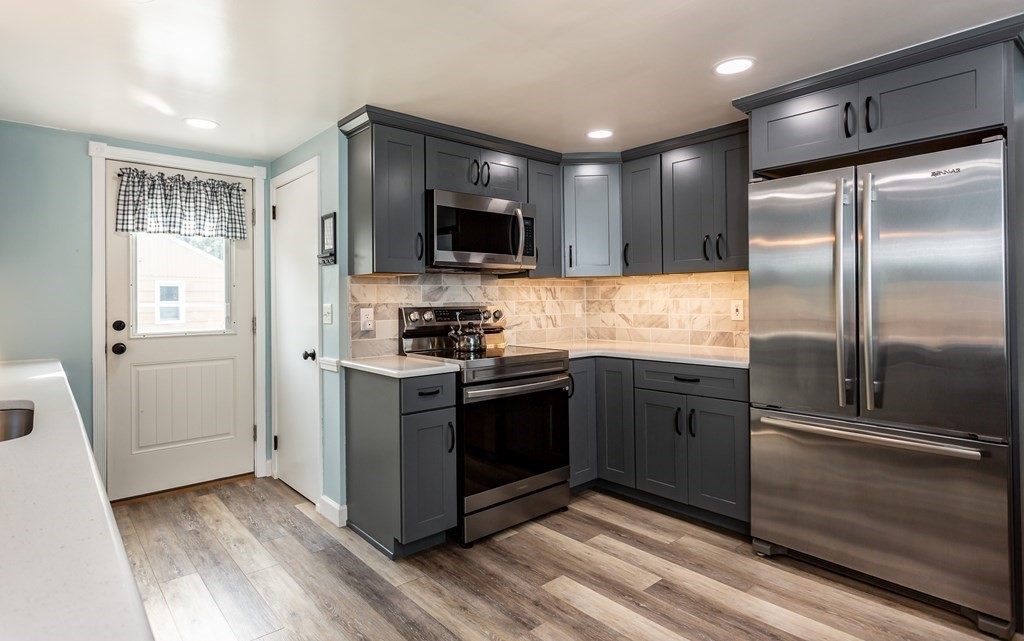 109 Oak Street Raynham, MA 02767 - Photo 3 of 25 a kitchen with stainless steel appliances kitchen island granite countertop a refrigerator and a stove top oven
