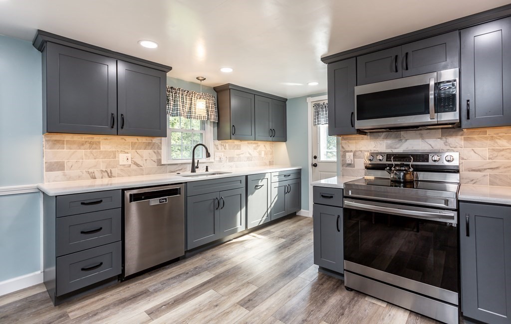 109 Oak Street Raynham, MA 02767 - Photo 4 of 25 a kitchen with stainless steel appliances a stove a sink and a microwave