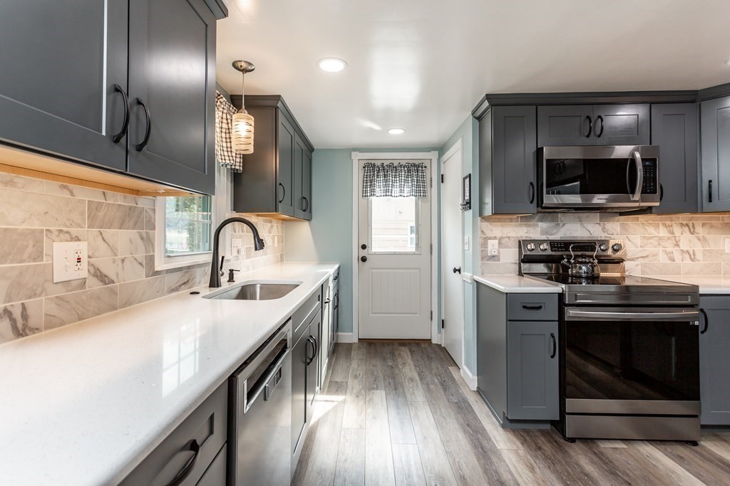 109 Oak Street Raynham, MA 02767 - Photo 5 of 25 a kitchen with stainless steel appliances a sink a stove and microwave