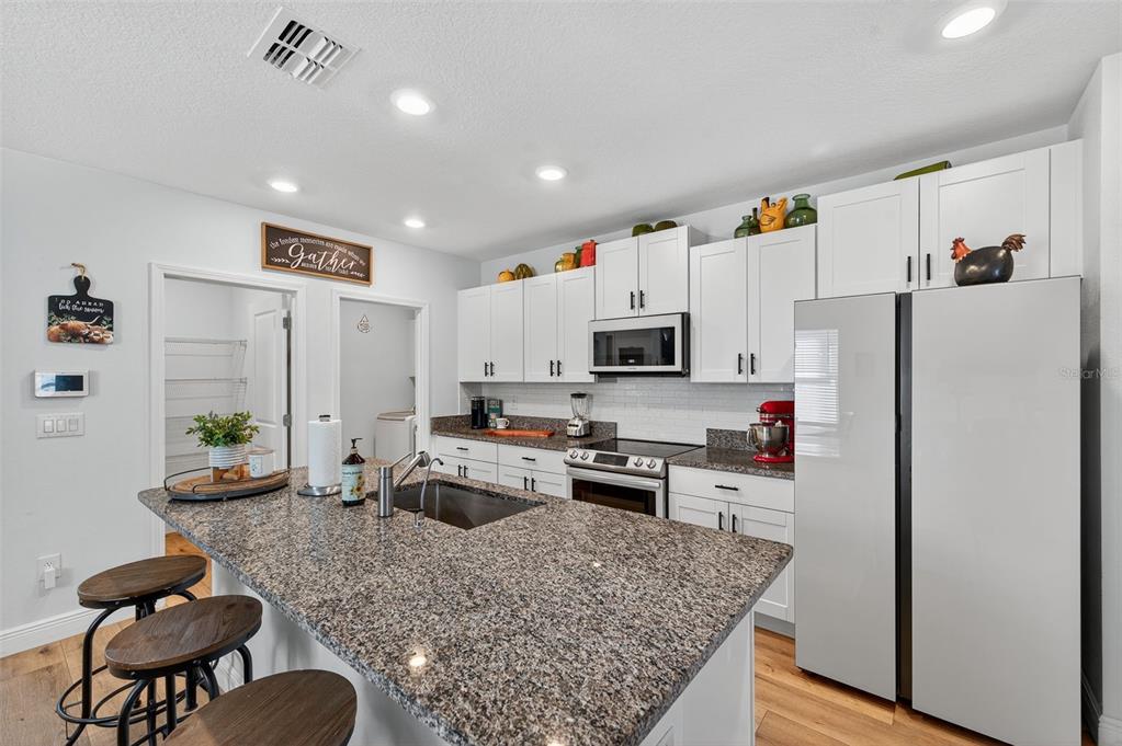 94 Rose Bud Ln Spring Hill Spring Hill, FL 34609 - Photo 12 of 38 a kitchen with stainless steel appliances granite countertop a refrigerator stove microwave and sink