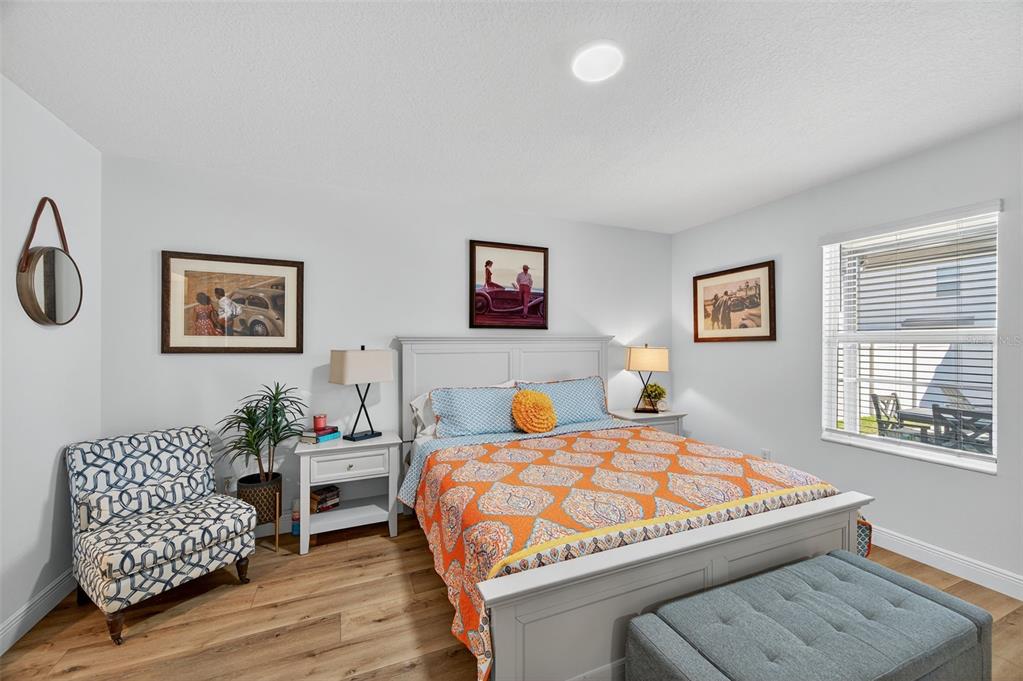 94 Rose Bud Ln Spring Hill Spring Hill, FL 34609 - Photo 16 of 38 a bedroom with a bed a dresser with wooden floor