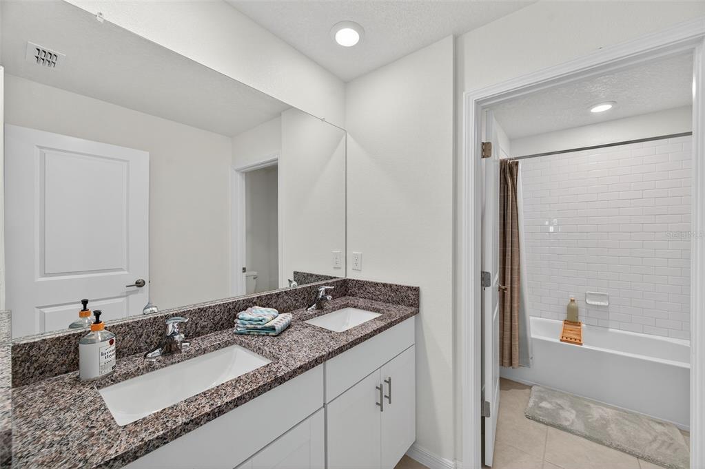 94 Rose Bud Ln Spring Hill Spring Hill, FL 34609 - Photo 33 of 38 a bathroom with a granite countertop sink and a mirror