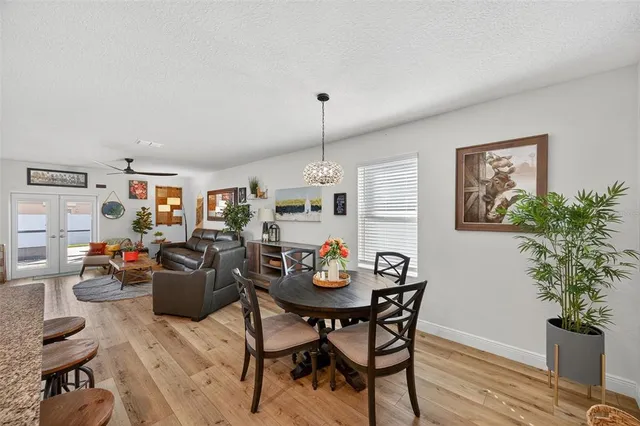 a view of a dining room and kitchen with furniture wooden floor a chandelier