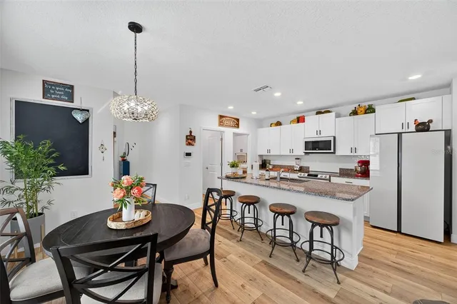 a room with stainless steel appliances kitchen island granite countertop furniture and a view of kitchen
