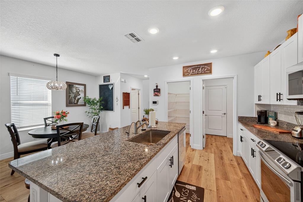 94 Rose Bud Ln Spring Hill Spring Hill, FL 34609 - Photo 10 of 38 a kitchen with stainless steel appliances granite countertop a sink stove and refrigerator