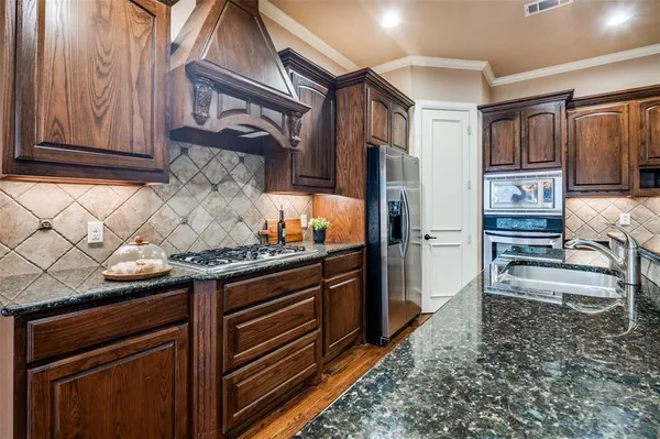 a kitchen with stainless steel appliances granite countertop a stove microwave and refrigerator