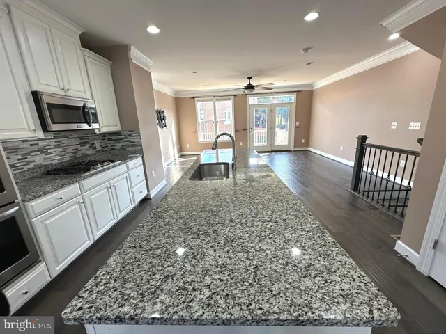 a large kitchen with cabinets table and chairs