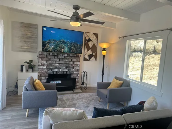 a kitchen with stainless steel appliances a refrigerator a stove a dining table and chairs with wooden floor