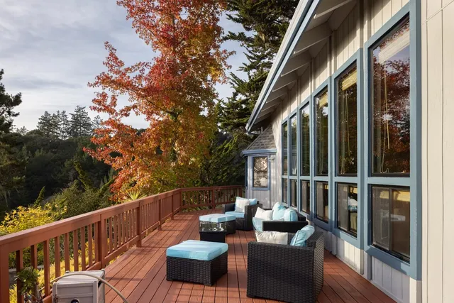 a balcony with wooden floor and outdoor seating