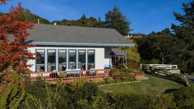 a view of a house with backyard garden and sitting area