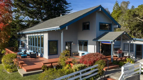 a front view of a house with porch and garden