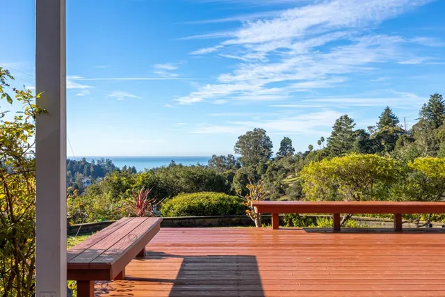 a view of balcony with wooden floor & fence