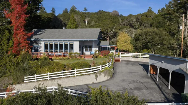 an aerial view of a house with swimming pool and a yard