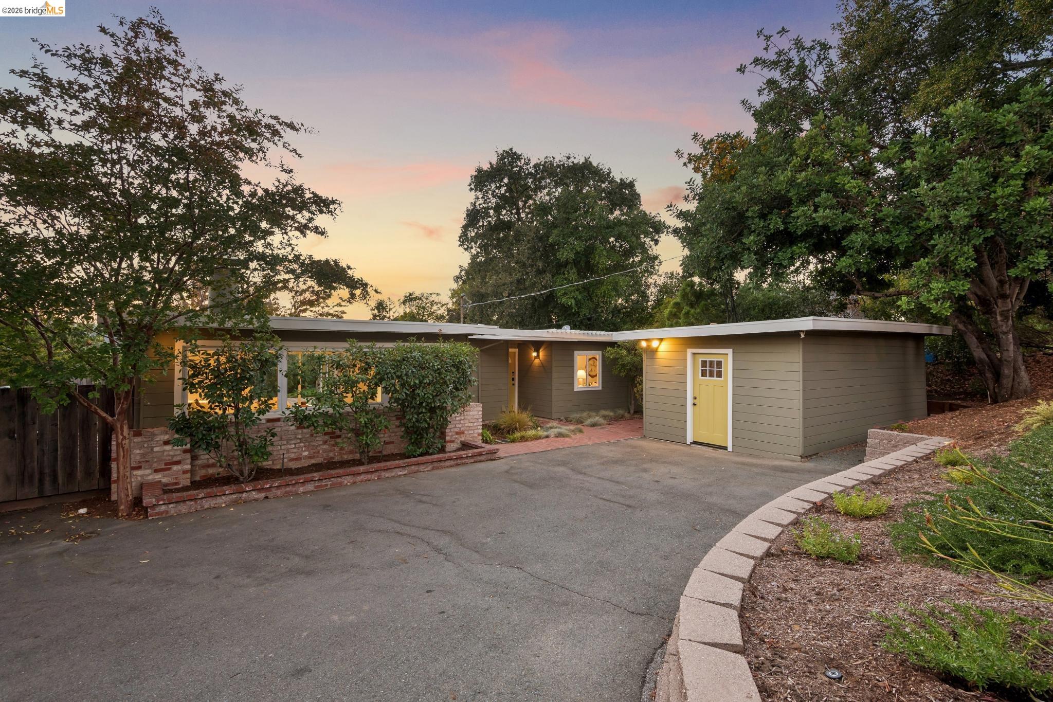 1321 Sunset Loop Lafayette, CA 94549 - Photo 2 of 49 Single-story exterior with horizontal siding, brick planter beds, and a paved driveway
