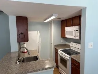 a kitchen with granite countertop a sink and a stove top oven