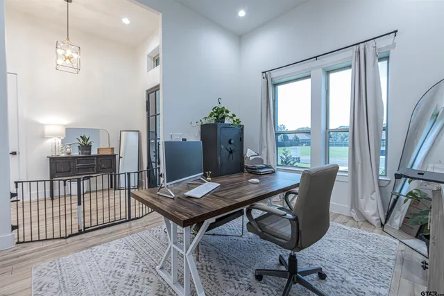a view of a workspace with furniture and a window